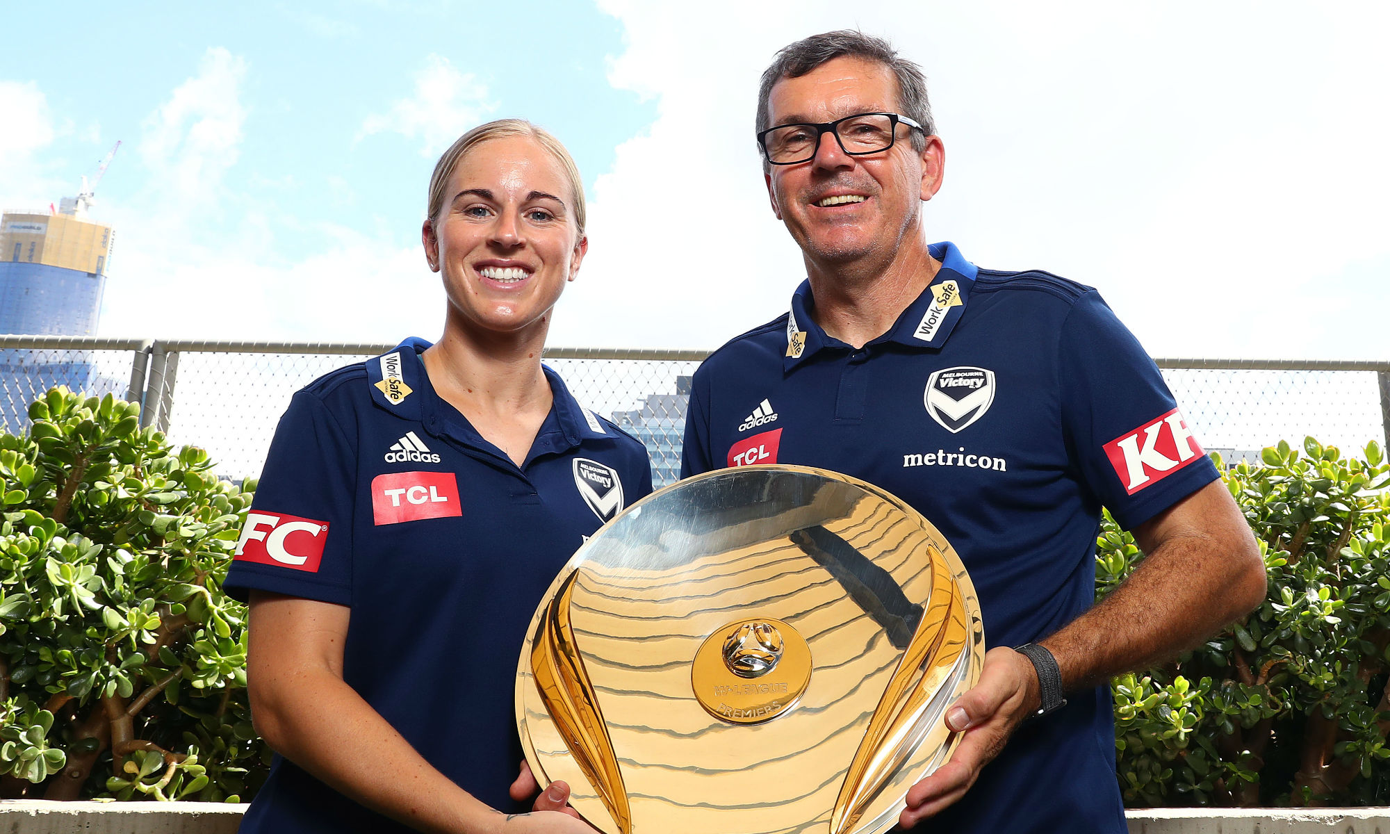 Natasha Dowie and Melbourne Victory head coach Jeff Hopkins hold the Westfield W-League Premiers Plate.
