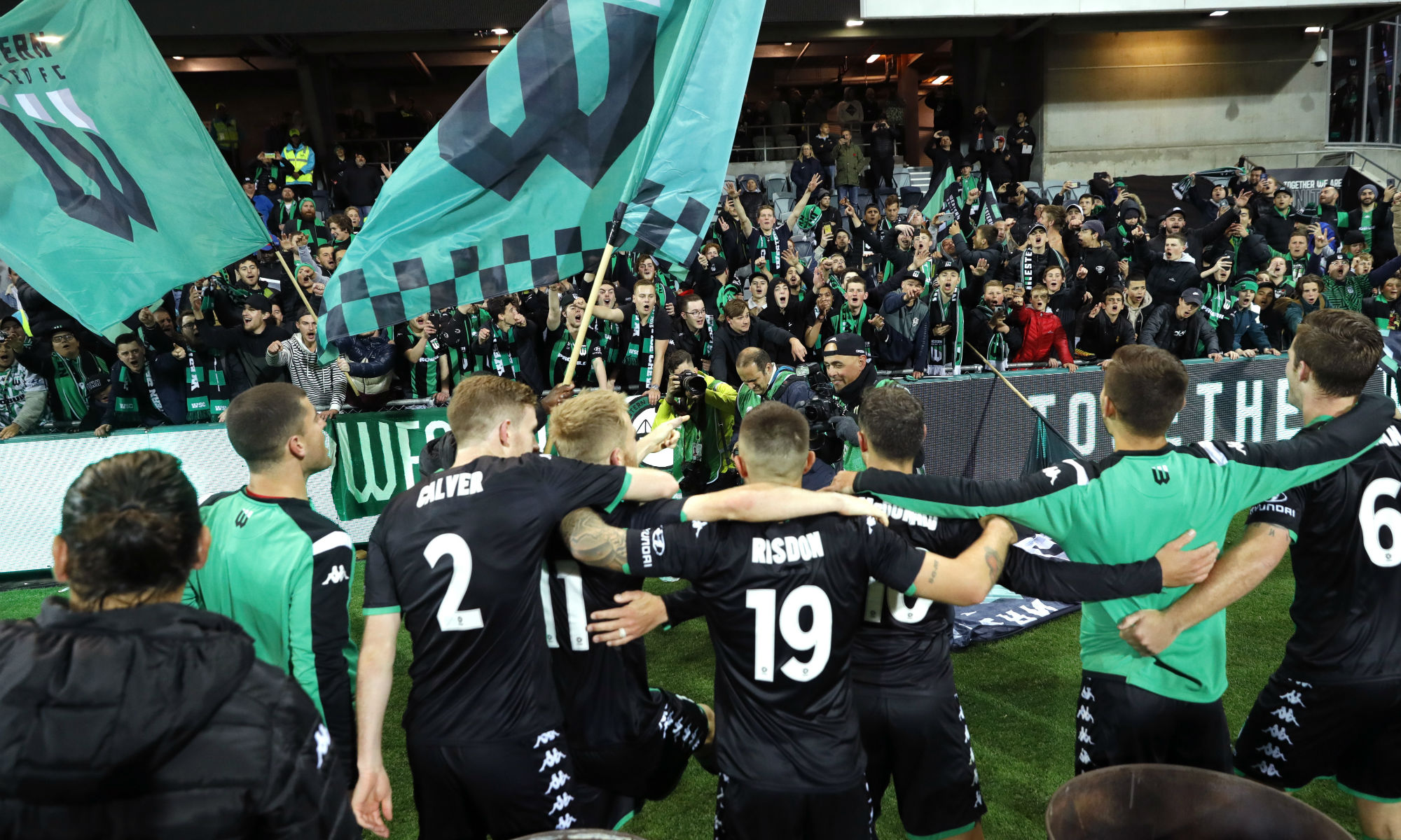 Western United players celebrate with the Western Service Crew behind the goal at GMHBA Stadium.