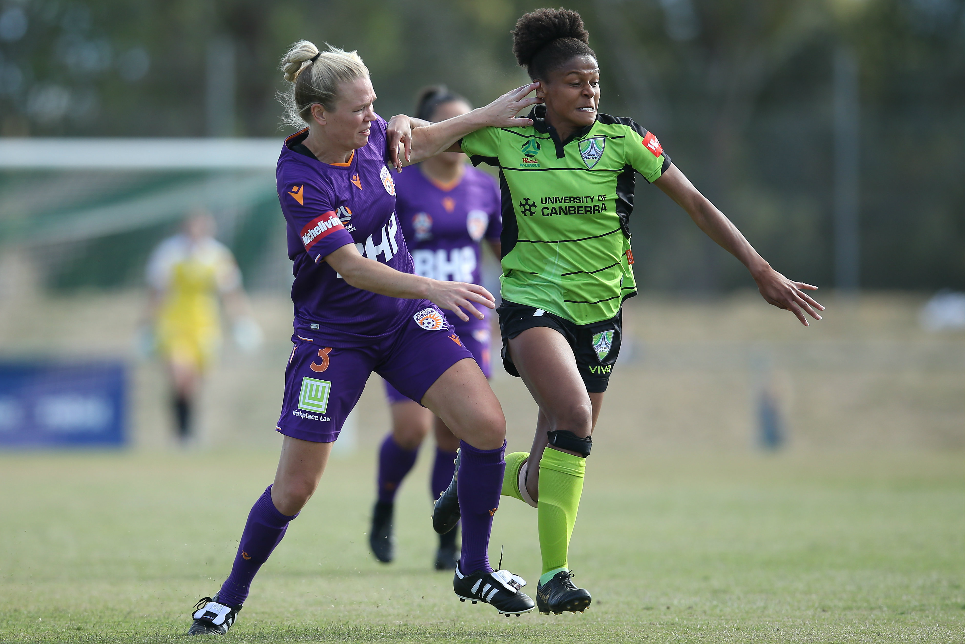 Kim Carroll and Simone Charley try to gain the initiative in the battle for the ball