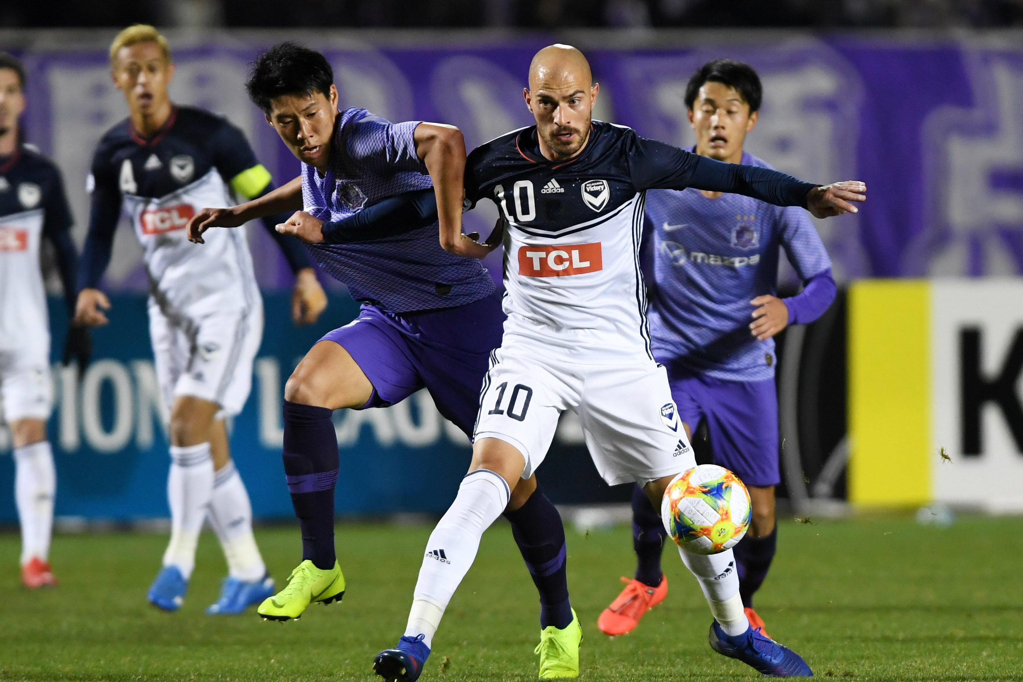 Victory's James Troisi holds off an opponent in the loss to Sanfrecce Hiroshima