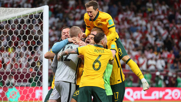 Craig Goodwin celebrates with his teammates after qualifying for the World Cup