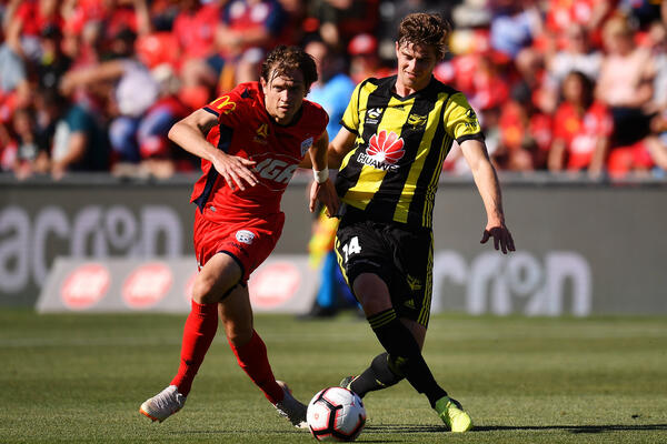 Adelaide attacker Craig Goodwin evades Phoenix midfielder Alex Rufer.
