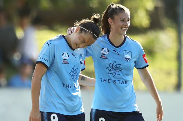 Caitlin Foord and Amy Harrison celebrate a goal against the Roar.