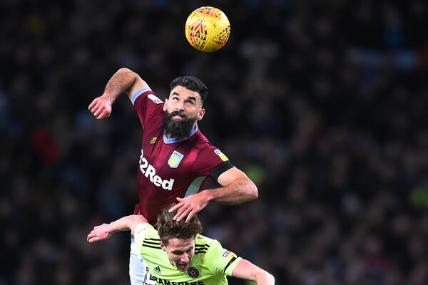 Mile Jedinak wins a header against Sheffield United