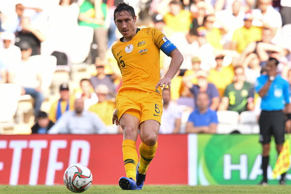 Socceroos skipper Mark Milligan gets a pass away.