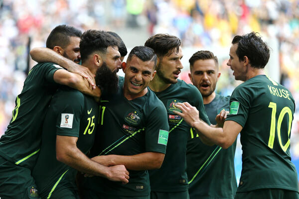 Australian players get around Mile Jedinak after his goal.